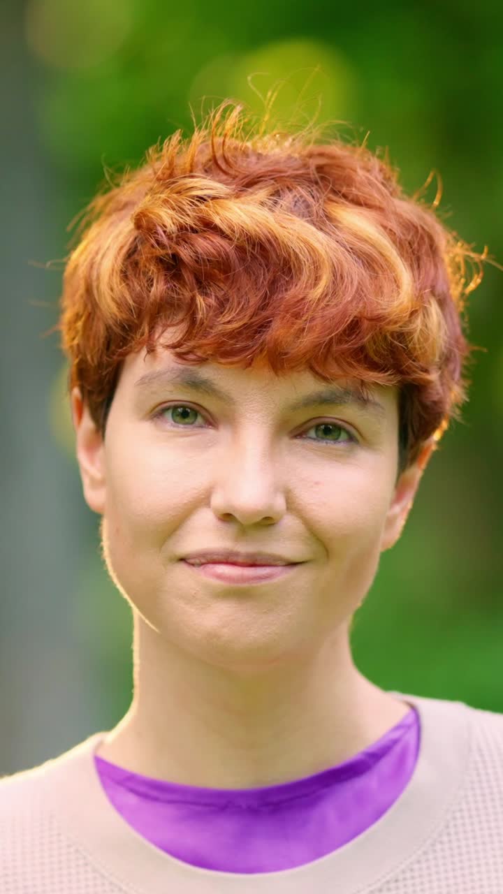 Close-up portrait of a woman with red hair and green eyes