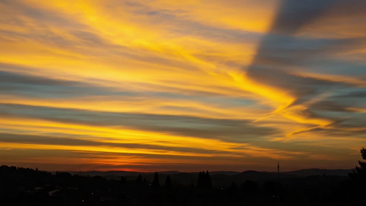 A breathtaking transition of colors in the sky captures the essence of a tranquil sunset, blending warm and cool hues over a serene landscape