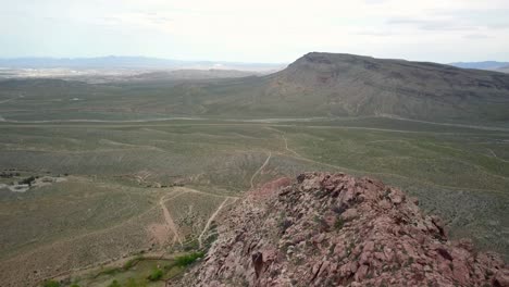 4k-Aéreo-Volando-Por-Los-Picos-Del-Cañón-De-Roca-Roja-Con-Las-Vegas-En-El-Fondo-Distante