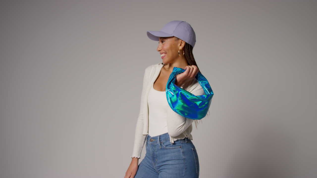 mujer influyente en las redes sociales produciendo contenido generado por el usuario modelando bolso de moda azul en el estudio