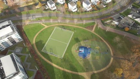 Aerial-of-green-playground-near-high-rise-buildings-in-autumn