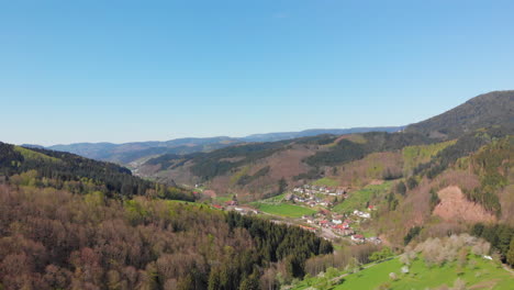 Aerial-pedestal-of-a-small-village-in-a-valley-surrounded-by-the-Blackforest,-Germany