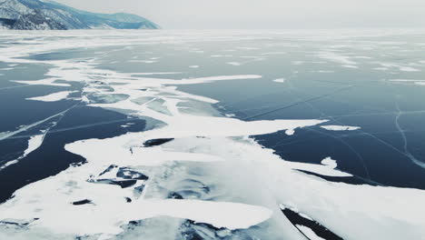 Paisaje-Aéreo-De-Imágenes-De-Lago-Congelado,-Lago-Baikal-En-Invierno-Con-Hielo-Azul-Roto-En-El-Cabo-Khoboy-En-La-Isla-De-Olkhon-En-Siberia,-Rusia,-Disparo-De-Drones