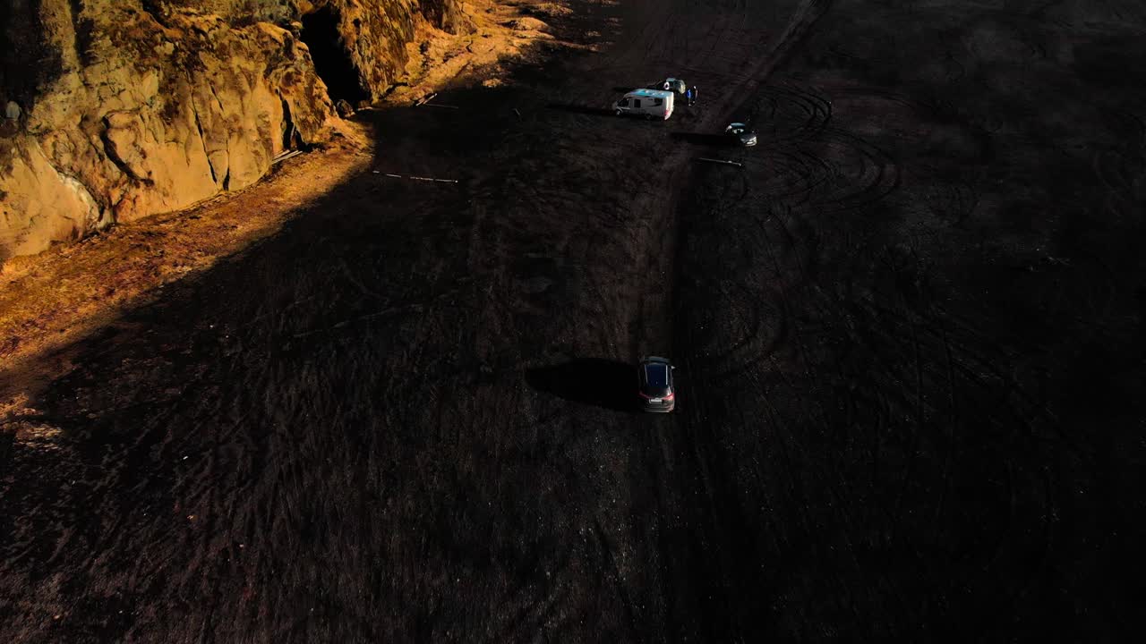 Aerial following Car top down on Iceland's Black beach