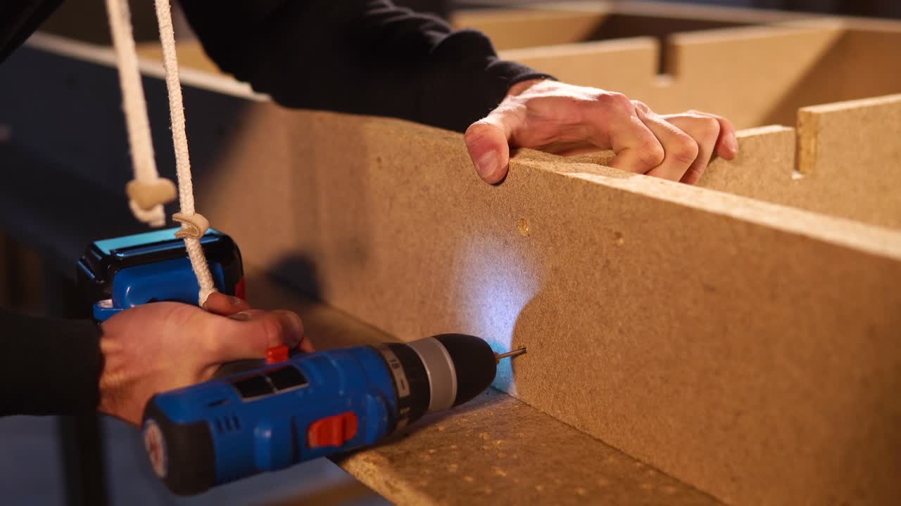 carpintero usando un taladro para montar tablas de madera