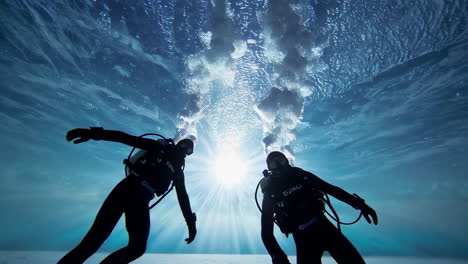 scuba divers in an underwater ice cave