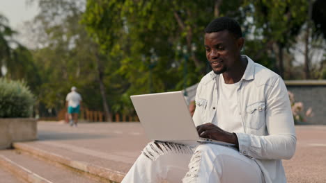 hombre trabajando en una computadora portátil en el parque