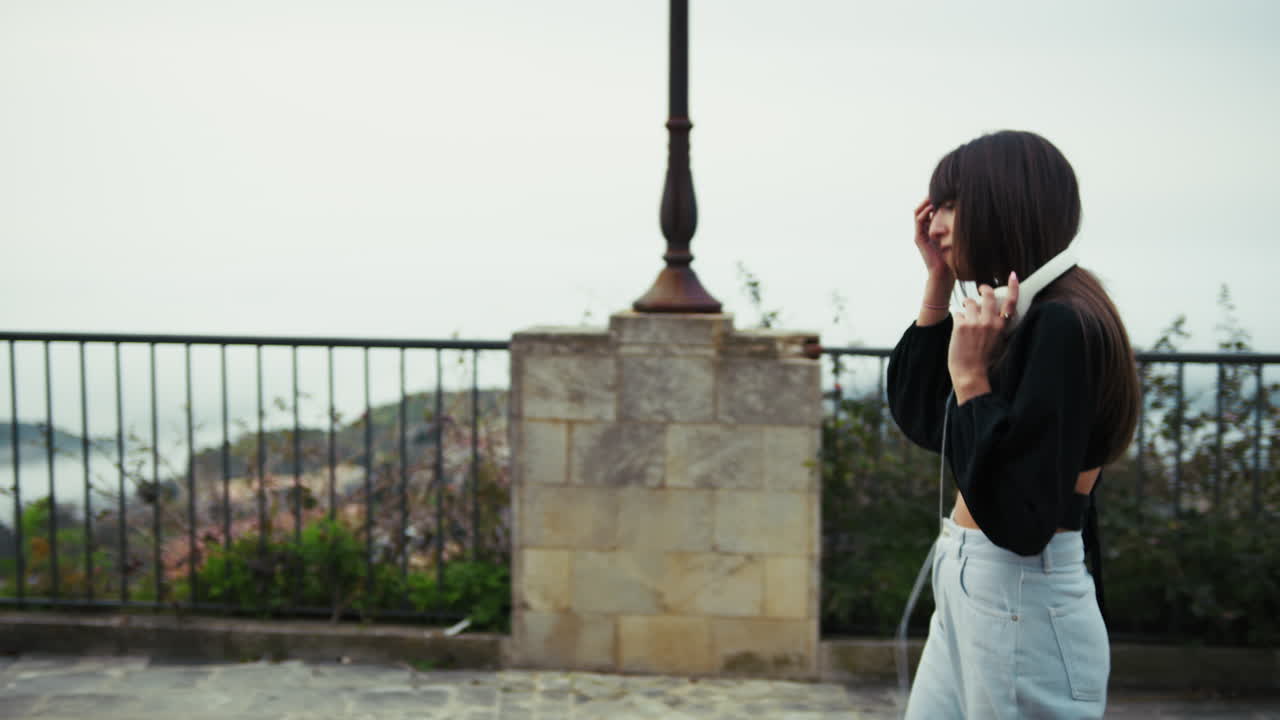 Woman Having A Walk Outdoor In The Italian Town With Headphones