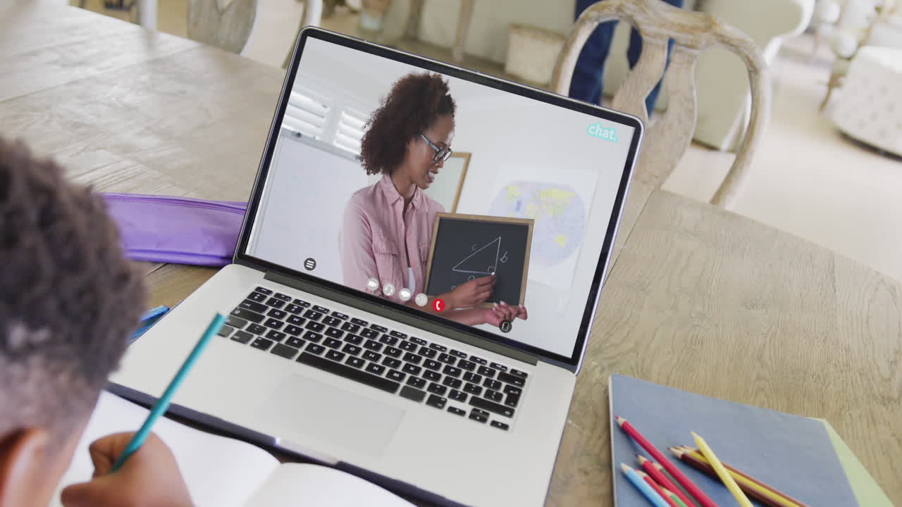estudiante varón diverso teniendo clase durante una llamada de video portátil con una maestra en cámara lenta