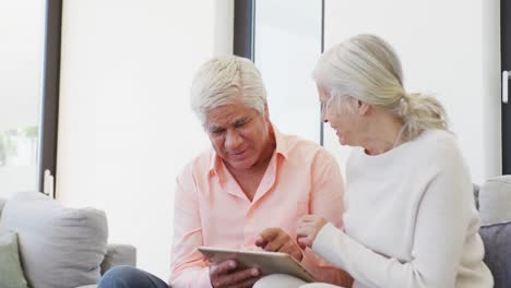 happy senior diverse people talking and using tablet at retirement home