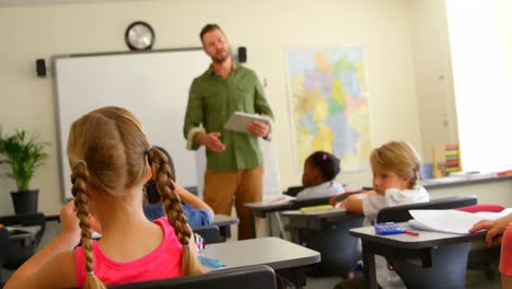 escolares multiétnicos estudiando en el escritorio en el aula de la escuela 4k