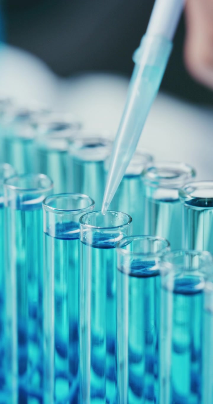 Scienziato che usa una pipetta per aggiungere liquido nelle provette in laboratorio