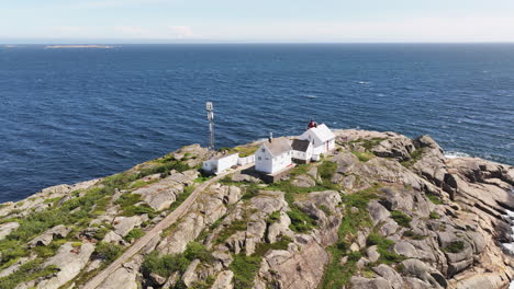 el faro de stavernsodden como luz guía durante mucho tiempo se encuentra en lo alto de la costa rocosa de stavern, noruega