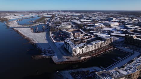 noorderhaven neighbourhood along river ijssel aerial with contemporary new luxury apartment building in bright snow cityscape and recreational port in the foreground