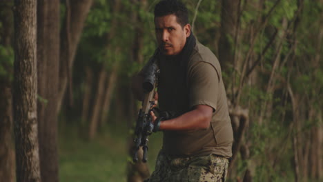 Hispanic-Soldier-In-Camouflage-Moving-Quietly-In-Forest-With-Assault-Rifle