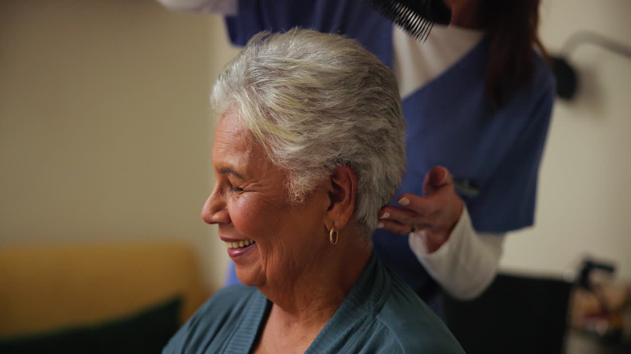 un cuidador ayuda a una anciana en silla de ruedas.
