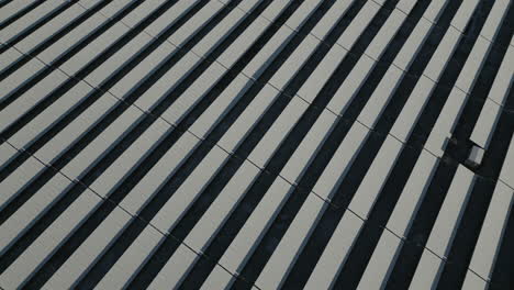 solar panels of solar power plant covered in snow and ice, diagonal lines, top down drone shot