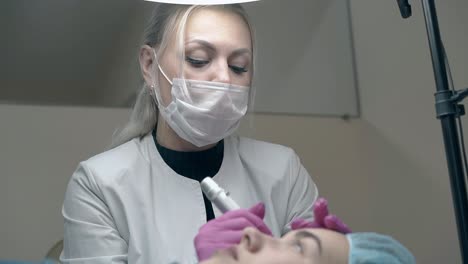 beautician talks to beauty salon guest applying make-up