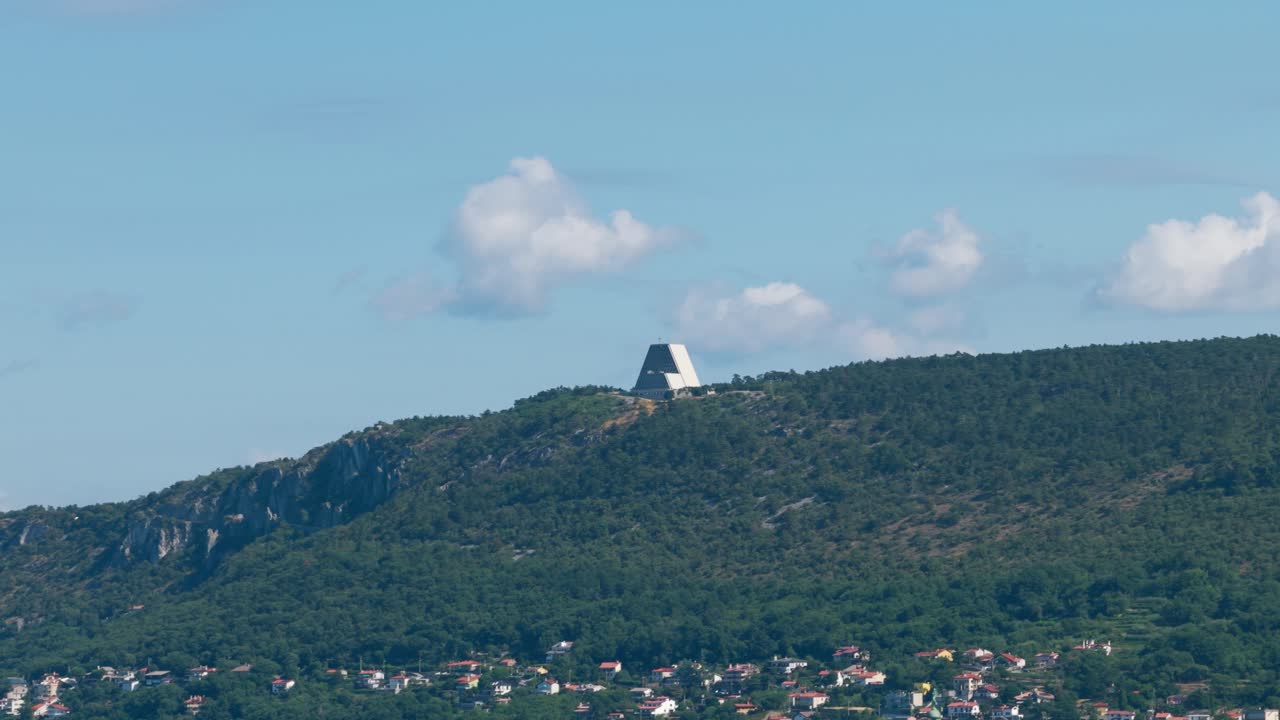 Temple of Monte Grisa, modern architecture on hilltop overlooking forest, Trieste, Italy. Aerial drone, copy space
