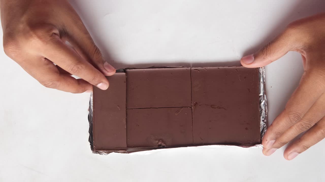 manos abriendo una barra de chocolate