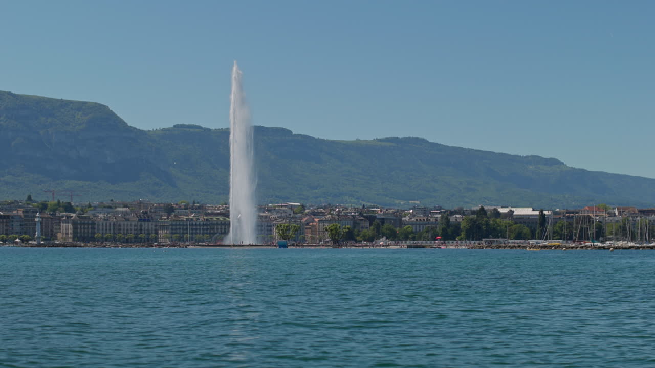 Peaceful morning in Geneva with the iconic Jet d’Eau rising from the lake, calm waters reflecting the clear sky, and the city slowly coming to life in the morning light.