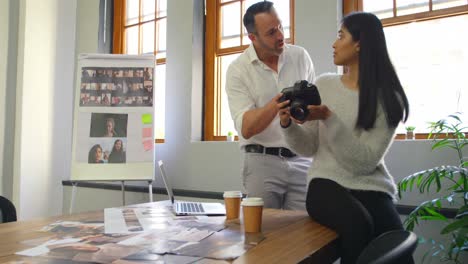 Diseñadores-Gráficos-Masculinos-Y-Femeninos-Discutiendo-Sobre-Una-Cámara-Digital-4k