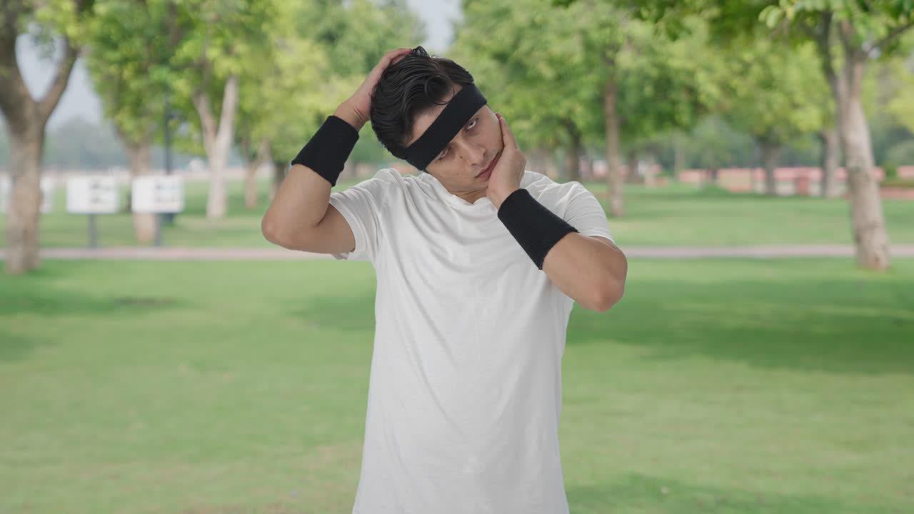 심각한 인디언 남자가 목 운동을 하고 있습니다.