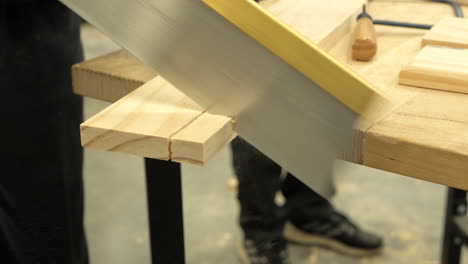 Student-Sawing-A-Piece-Of-Timber-In-Woodwork-Class,-CLOSE-UP