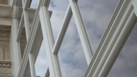 Rotating-slow-motion-shot-of-beautiful-blue-sky-with-clouds-reflected-in-white-window