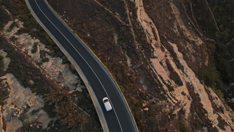 Vista-Aérea-Superior-De-Un-Hombre-Corriendo,-Trotando-Al-Atardecer-Mientras-El-Coche-Pasa