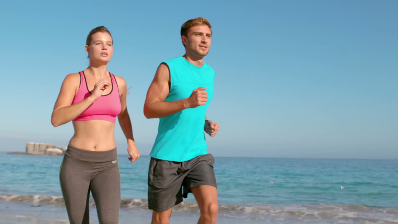 pareja corriendo en la playa