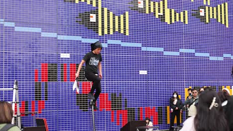 performer throws knives while balancing on unicycle.