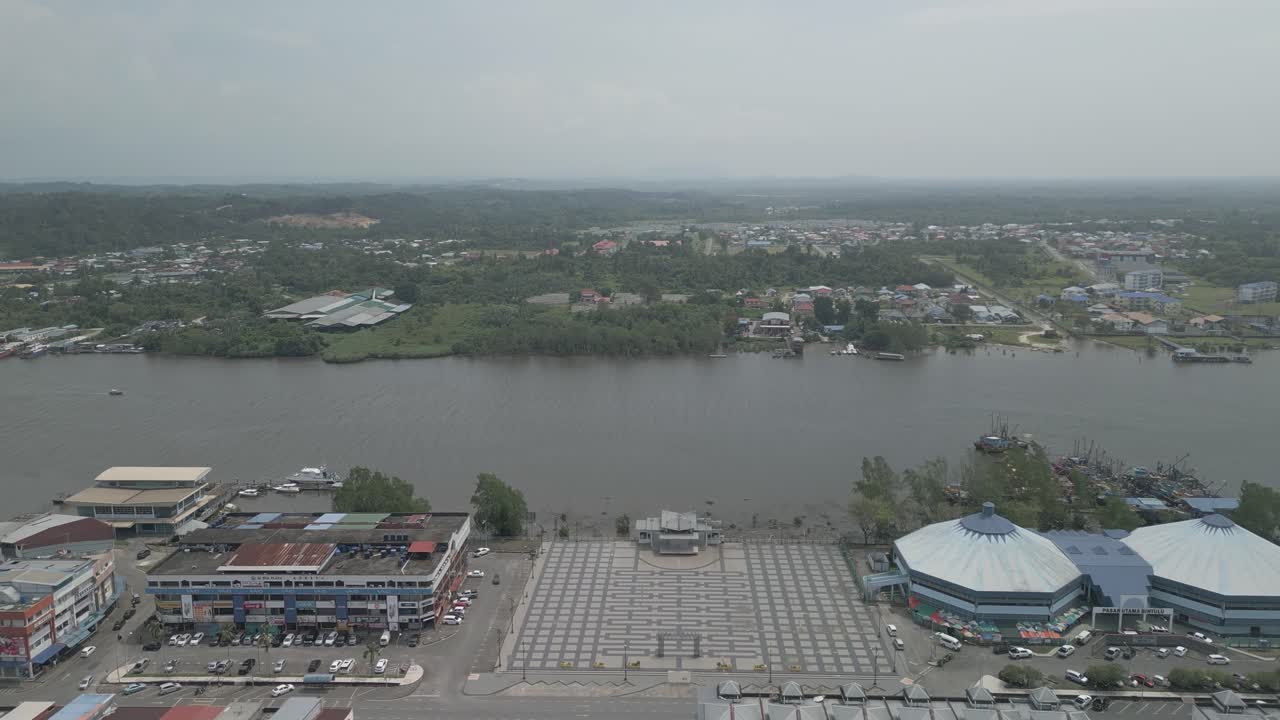 Splendida vista aerea con drone della città di Bintulu, Sarawak, con fiume, barca e piccola nave mercantile, accanto al mercato umido e, sullo sfondo, il nuovo ponte di Bintulu e anche una piccola pista di atterraggio inutilizzata.