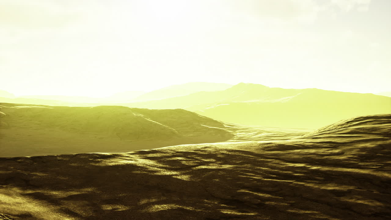 Golden light spills over rolling hills in a serene landscape during dawn