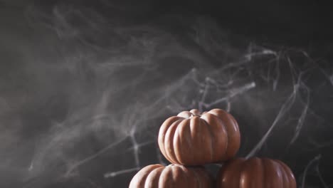 Video-of-halloween-pumpkins-and-smoke-with-copy-space-on-grey-background