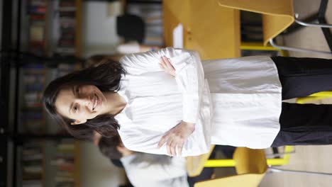 Linda-Chica-Positiva-Con-Cabello-Negro-Con-Camisa-Estudiante-O-Profesor-Mirando-La-Cámara-Sonriendo-Amigable