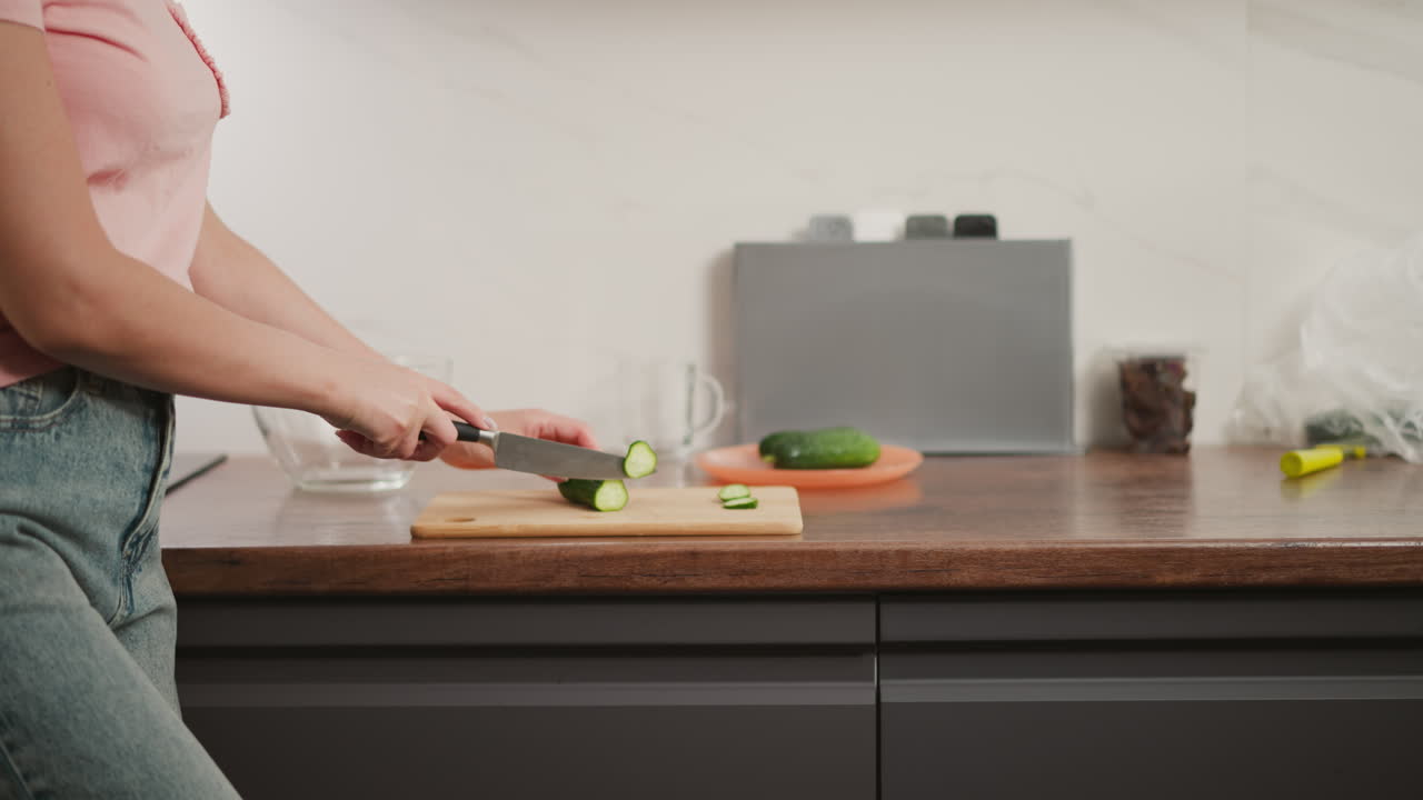 mujer cortando pepino en la cocina