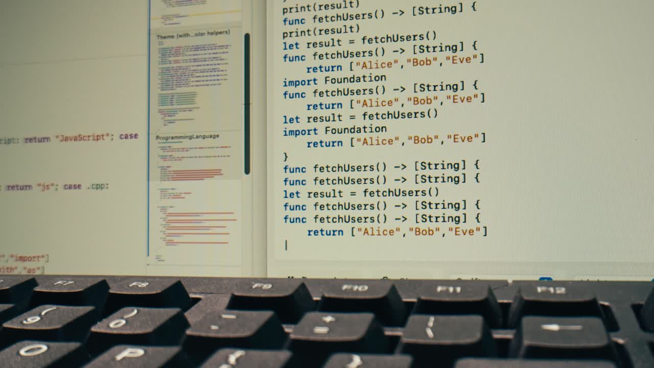 Programovací kód na obrazovce počítače s klávesnicí v popředí
