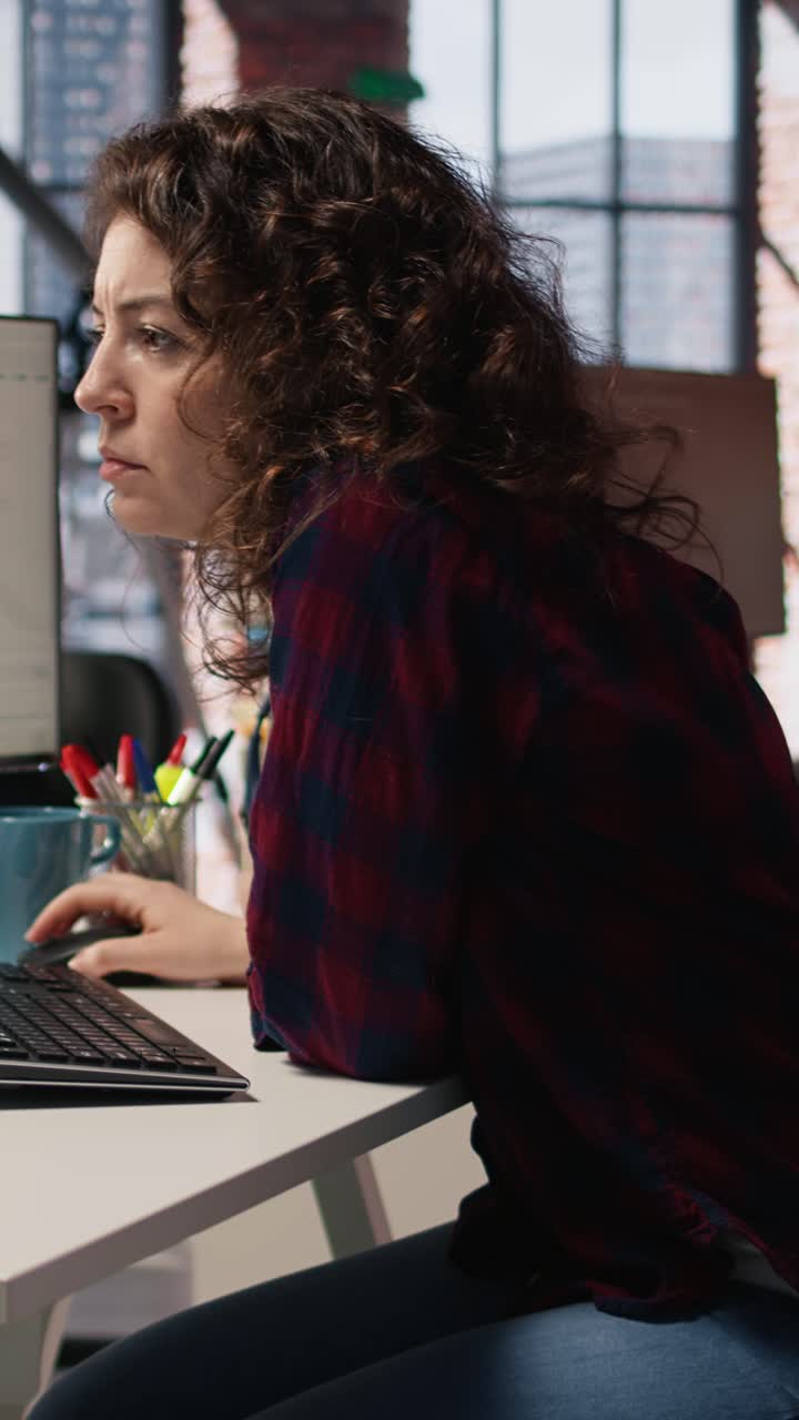 Vertical video Cheerful IT expert using programming languages on PC in IT startup office