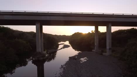 aerial - camera goes under bridge filming waterway