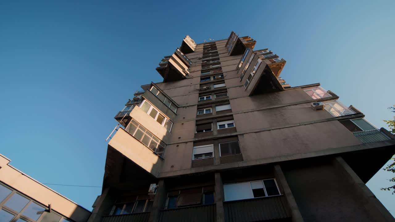 Low-angle aerial view of Belgrade’s Houding Tower in Karaburma, Serbia, highlighting brutalist architecture, geometric concrete design, and urban skyline perspective