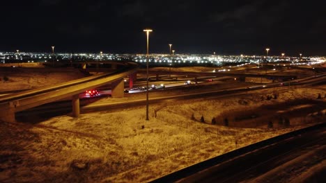 Aerial-orbit-around-car-crash-below-highway-overpass-at-night