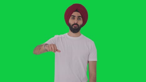 disappointed sikh indian man showing thumbs down green screen