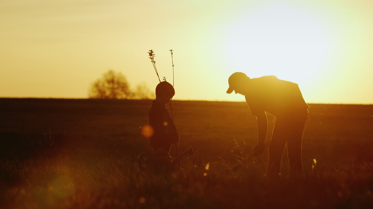 un padre con un hijo pequeño juntos plantan un árbol
