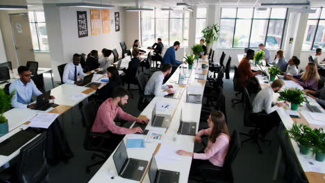 busy open-plan office with professionals working at their desks