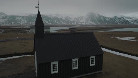 aerial approach of black church of budir religious building in iceland