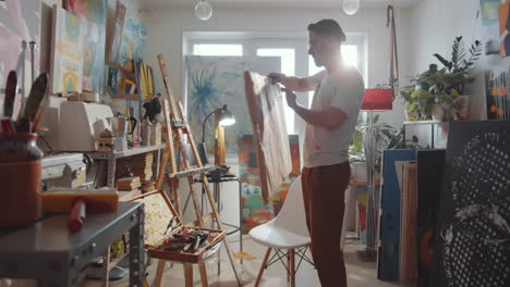 artist putting blank canvas on easel