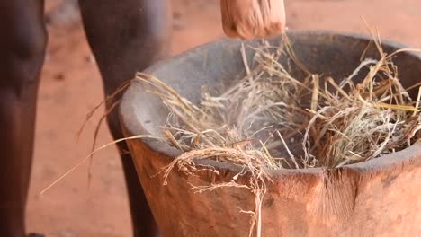 crop woman grinding hay with mortar