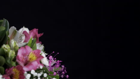 Golden-white-and-purple-flower-arrangement-spinning-black-background-slider-shot-detail-shot