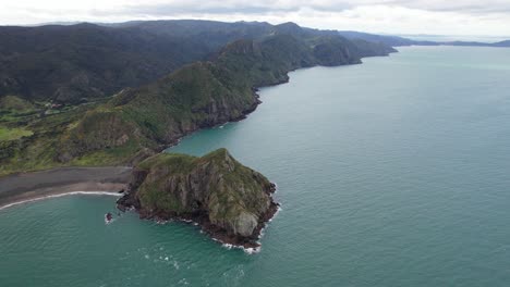 waitakere ranges and paratutae island at the mouth of manukau harbour in auckland, new zealand